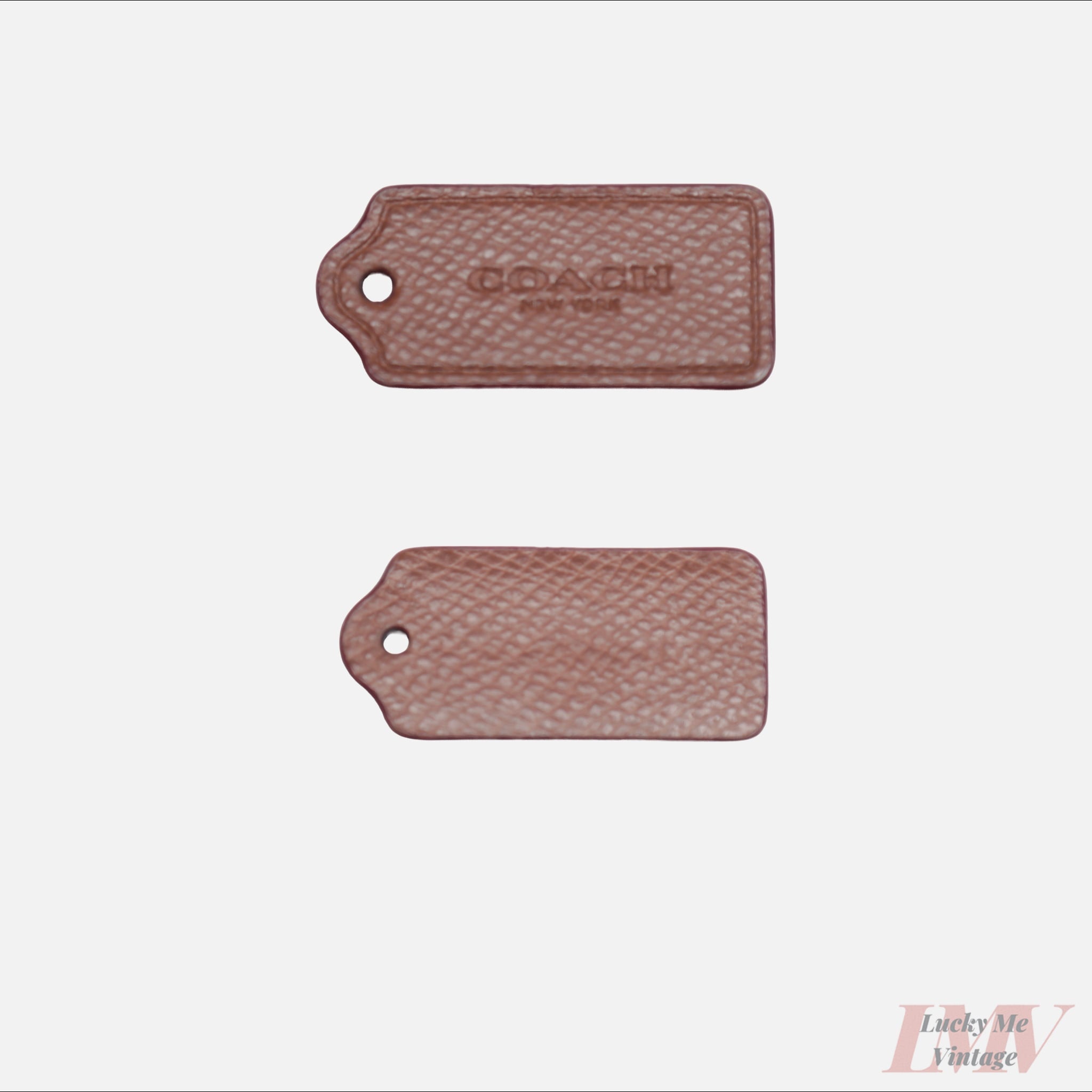 Two 2.5 inch medium brown color leather tags showing front and back with 'Coach' branding on a white background. 